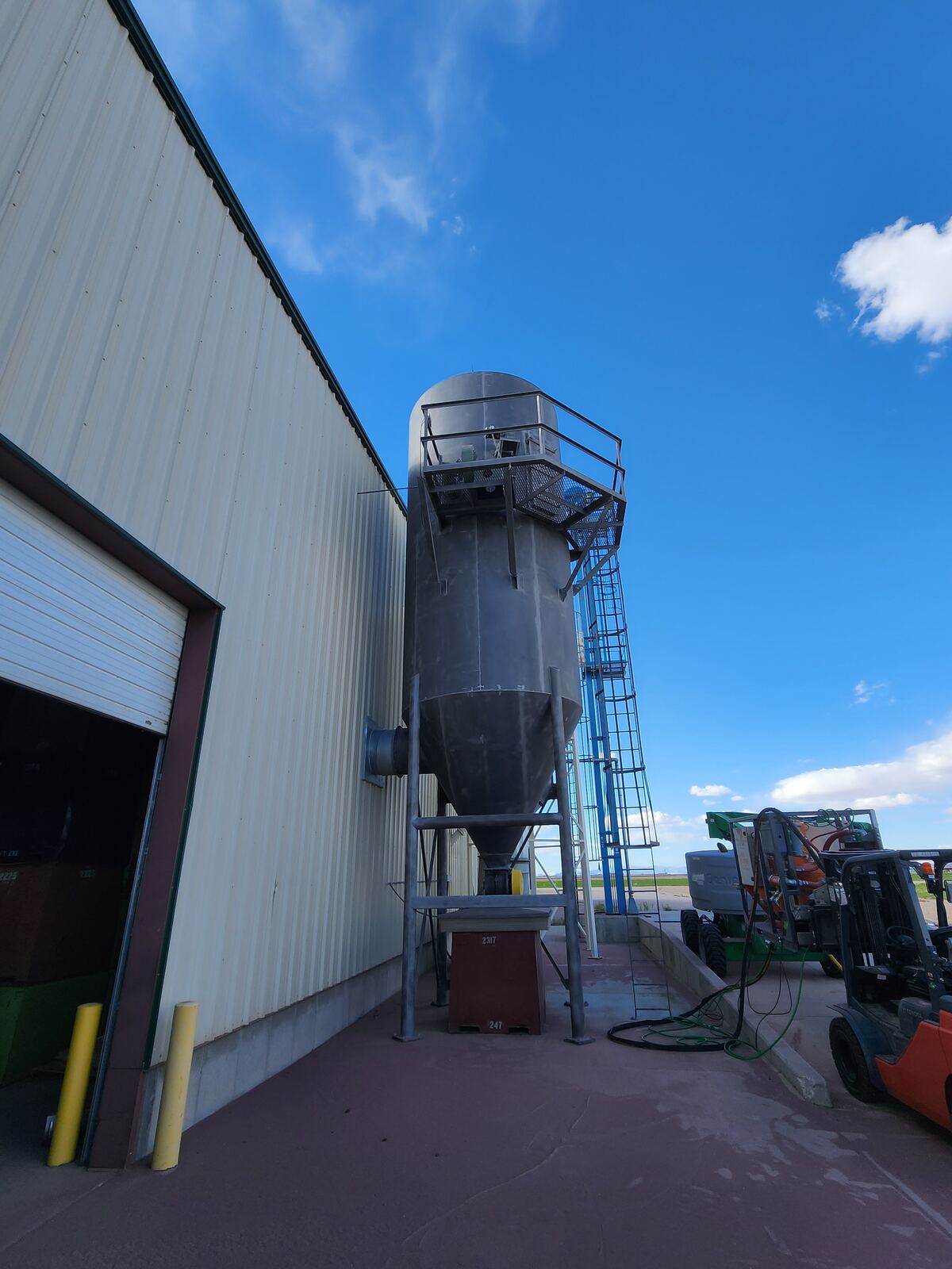 The same tank sandblasted to bare steel, stripped on-site from a boom lift