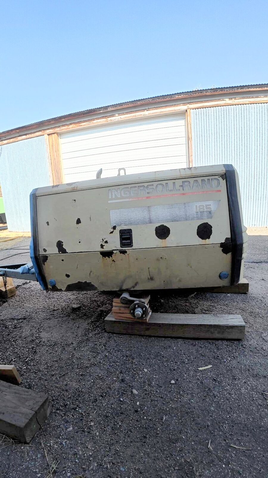 The 1999 Ingersoll Rand 185 compressor with peeling paint and rust after years of outdoor storage